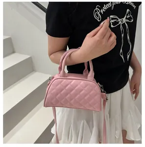 Detail of pink quilted Boston bag with silver hardware and detachable crossbody strap