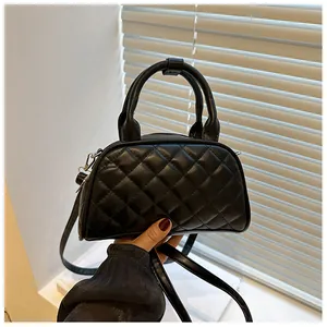 Detail showing the quilted rhombic texture and handle of the black PU leather Boston bag