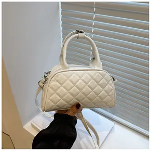 Detailed close-up of a white quilted crossbody bag with silver hardware and dual handles