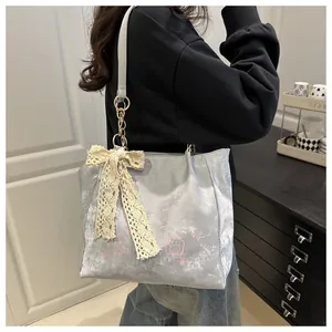 Detail of grey velvet tote bag with a pink cartoon print and large lace bow charm