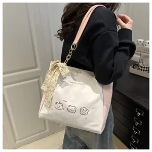 Detail of pink leather shoulder strap and white lace bow on the printed canvas tote