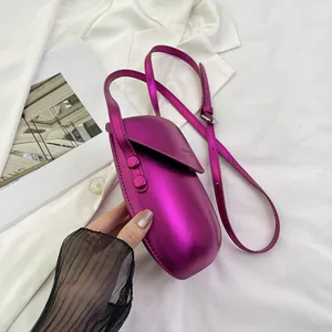 Metallic rose pink mini saddle crossbody bag with a glossy finish and adjustable strap