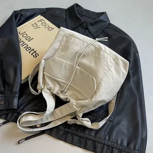 Sac à dos en nylon beige avec cordon de serrage, multiples poches et bandoulière large