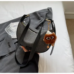 Détail du sac hobo tissé avec bandoulière en cuir noir et breloque peluche