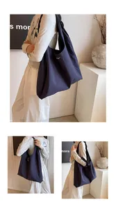 Detail shot of a dark blue nylon tote bag showing its spacious capacity and fabric texture