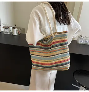 Detail of colorful striped straw tote bag with braided rope handles in a casual setting