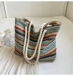 Close-up of colorful striped woven tote bag with white rope handles and knit texture