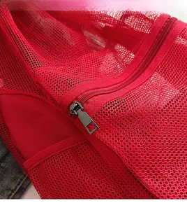 Detailed close-up of the smooth metal zipper and red mesh fabric of the drawstring bag