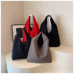 Detailed display of four colorful nylon tote bags on minimalist curved pedestals