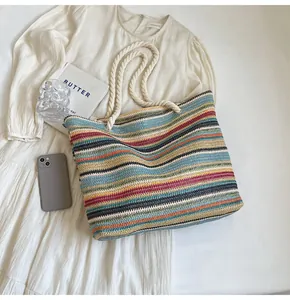 Flat lay of colorful woven straw tote bag on a dress with summer vacation accessories