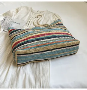 Detailed close-up of colorful striped woven straw tote bag with natural rope handles