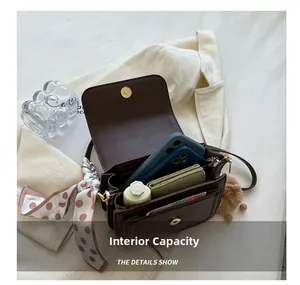 Detail view of the brown leather bag interior showing multiple compartments and storage