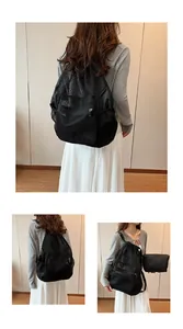 Detail view of black mesh drawstring backpack with side pockets and matching pouch