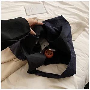 Top view of navy blue nylon tote bag showing spacious interior with daily cosmetics