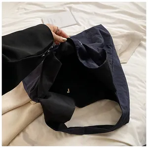 Detailed view of dark blue nylon tote bag showing spacious interior and magnetic closure