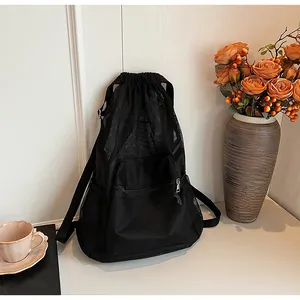Detail of black mesh drawstring backpack with breathable fabric and front zipper pocket