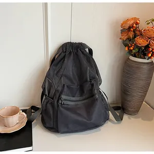 Detail of breathable black mesh drawstring bag with front zipper pocket and side mesh pocket