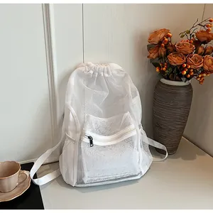 Detail of white mesh drawstring backpack featuring breathable large-hole texture and front pocket