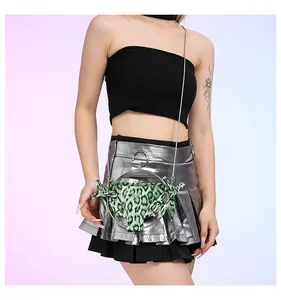 Gros plan du mini sac bikini léopard vert avec chaîne et détails papillon élégants