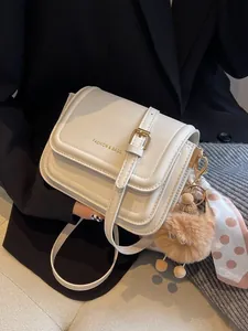 Chic beige crossbody square bag with gold lettering, scarf accent and plush pendant