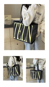 Détail du grand sac cabas en toile noire avec texte TELN jaune et texture robuste