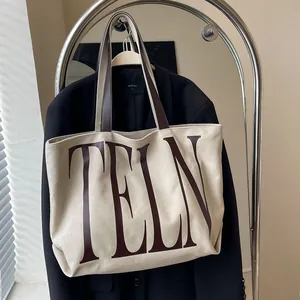Sac cabas minimaliste en toile avec anses marron et imprimé TELN sur un support