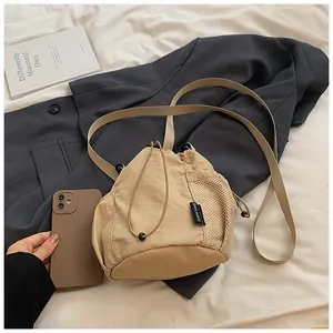 Detailed close-up of khaki nylon drawstring bucket bag showing mesh side pocket and phone size