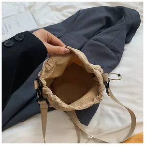 Detailed top view of beige nylon bucket bag showing spacious interior and drawstring closure