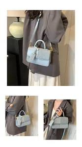 Detail of light blue patchwork crossbody bag with gold hardware and textured finish