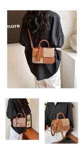 Detail of a brown leather and tweed patchwork handbag with a fashion tag and gold hardware