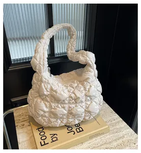 Détail du sac matelassé blanc montrant la texture moelleuse sur un marbre chic