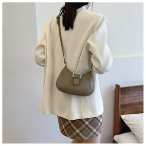 Détail du sac sous l'épaule vert olive avec boucle en métal argenté et texture grainée