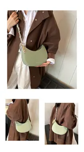 Détail du sac demi-lune vert menthe avec une poignée décorée d'un foulard en soie