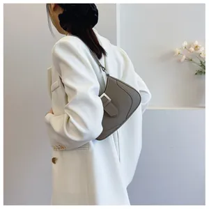 Détail d'un sac à bandoulière en cuir grainé gris foncé avec boucle en métal argenté