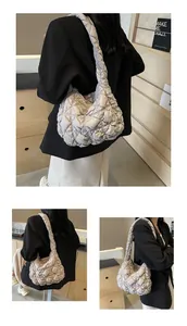 Détail du sac nuage matelassé gris clair avec texture plissée et bandoulière intégrée