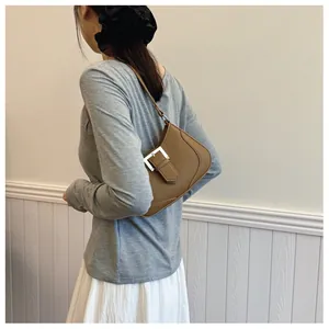 Détail d'un sac à bandoulière en cuir marron avec boucle argentée et grain lychee
