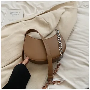 Détail du sac bandoulière demi-lune marron avec chaîne argentée et foulard en soie