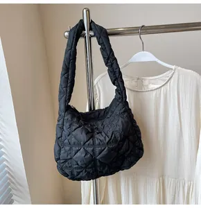 Détail du sac à bandoulière matelassé noir montrant la texture en nylon et le zip
