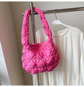 Gros plan du sac matelassé rose vif montrant la texture plissée et le nylon gonflant