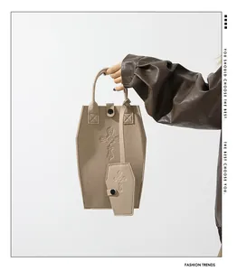 Detailed view of khaki coffin-shaped tote bag with cross embossing and mini charm