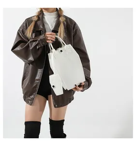 White coffin-shaped bucket bag with cross relief detail and matching mini pouch