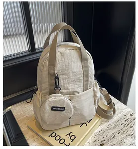 Détail du sac à dos en nylon beige avec texture plissée et porte-monnaie rond amovible