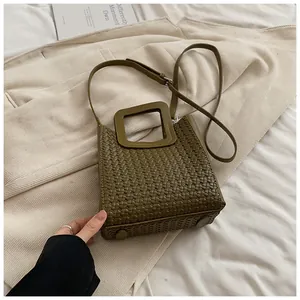 Gros plan détaillé de la texture tissée et de l'anse carrée du sac seau vert olive