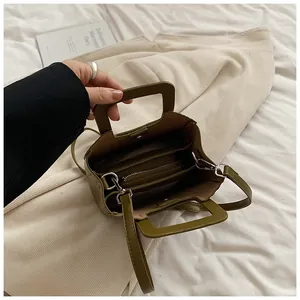 Vue détaillée du sac vert olive montrant les compartiments internes et la poignée