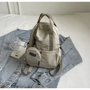 Détail du sac à dos en nylon beige avec porte-monnaie rond amovible et cordon de serrage