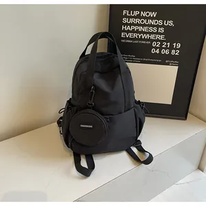 Détail d'un sac à dos en nylon noir avec porte-monnaie rond amovible et poches à cordon
