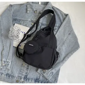 Détail du sac à dos en nylon noir sur denim avec pochette ronde amovible et sangle tissée