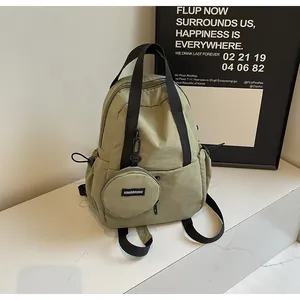 Détail d'un sac à dos en nylon vert olive avec porte-monnaie rond amovible et anses noires