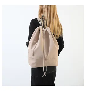 Detailansicht eines beigen Kordelzug-Rucksacks aus Kunstleder mit silbernen Beschlägen