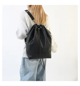 Rückansicht eines minimalistischen schwarzen Kordelzug-Rucksacks am Modell im Studio